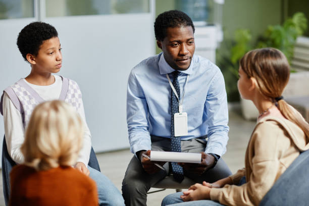 Group of students and an adult sitting in a group talking.